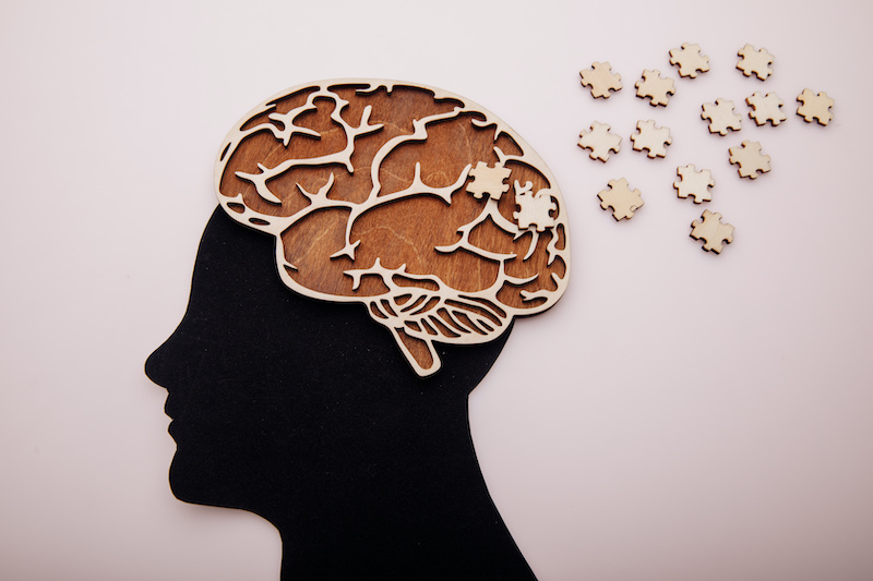 Head of man with brain and wooden puzzle. Alzheimer's disease, dementia and mental health concept.