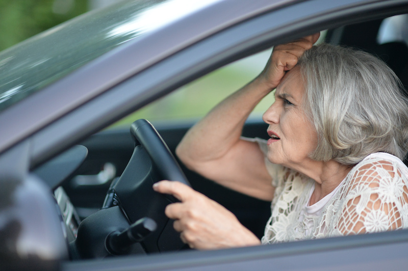 portrait of stressed senior woman driving car