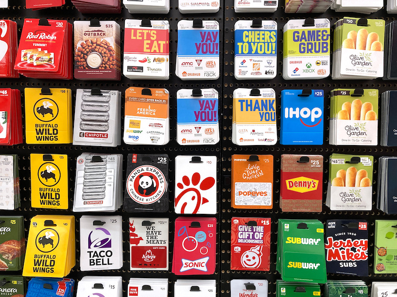 Multiple types of fast food and restaurant gift cards displayed on stand. Including Panda Express, Chick-fil-A, Taco Bell, IHOP, Chipotle, Subway - California, USA - 2023