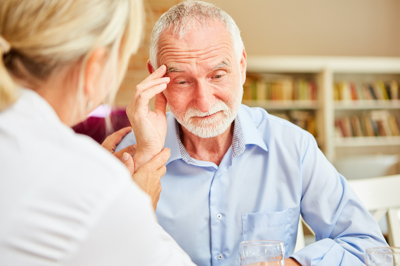 Senior with dementia or Alzheimer's is comforted by caring female doctor