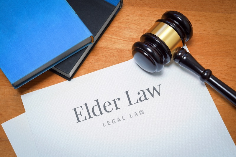 Elder Law. Document with label. Desk with books and judges gavel in a lawyer's office.