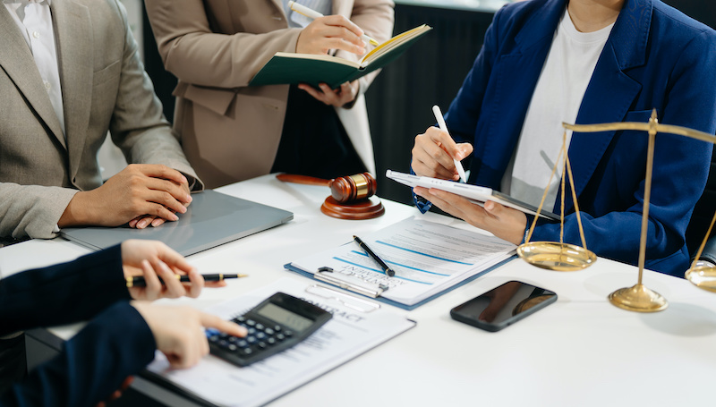 business people and lawyers discussing contract papers sitting at the table. Concepts of law, advice, legal services. in morning light