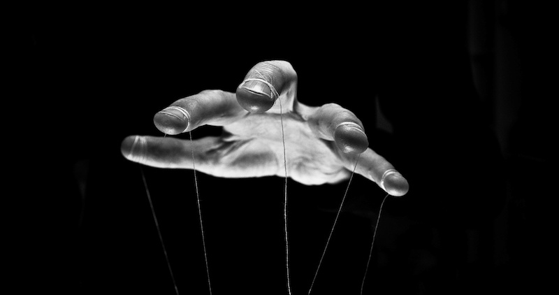 Eerie puppeteer hands controlling you. Manipulation concept