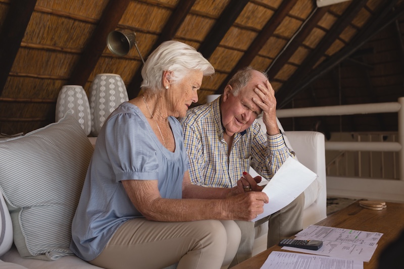 Senior couple discussing over medical bills in living room