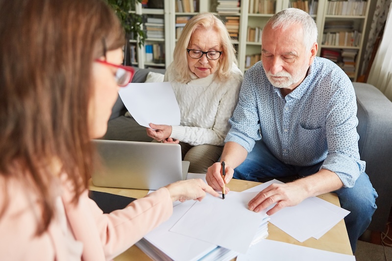 Seniors sign a contract or power of attorney after a home counseling session
