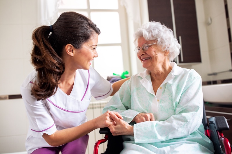 Nurse attending senior woman in a long term care facility, concept of trust between medical staff and home occupants