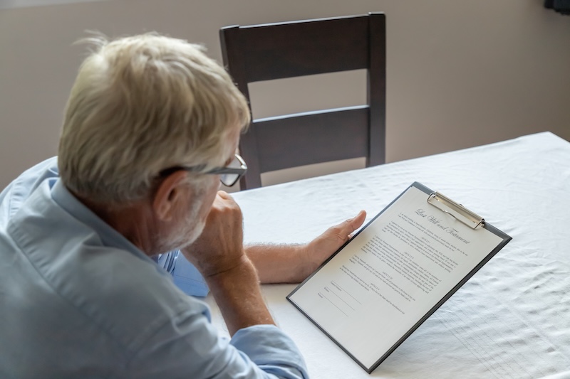 Senior old man elderly examining and checking last will and testament